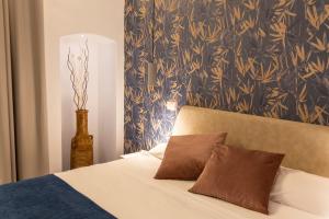 łóżko z dwoma brązowymi poduszkami na górze w obiekcie Porta Vetere - Boutique Rooms w mieście Trani