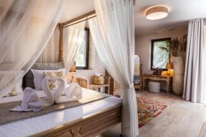 - une chambre avec un lit à baldaquin et deux oreillers en cygne dans l'établissement Boutique Hotel Horizont, à Varna