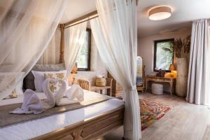 a bedroom with a canopy bed with two swans pillows at Boutique Hotel Horizont in Varna City