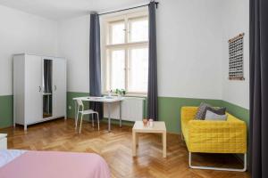 Zimmer mit einem Tisch, einem Stuhl und einem Schreibtisch in der Unterkunft Letná Apartments in Prag