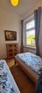 a bedroom with two beds and a window at 3Zimmer-Wohnküche-Altbau-90m2-eigener Parkplatz in Oberhausen