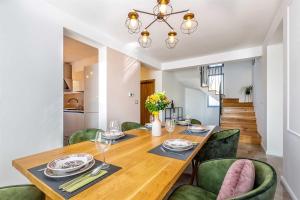 a dining room with a wooden table and green chairs at Luxury apartment Viktorija with private pool in Čižići