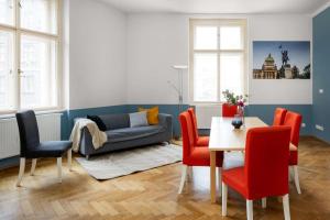 een woonkamer met een tafel en stoelen en een bank bij Letná Apartments in Praag