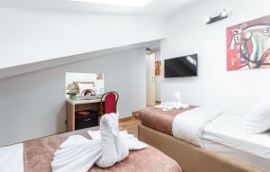 a hotel room with two beds and a tv at Hotel Dua Residence in Poreč