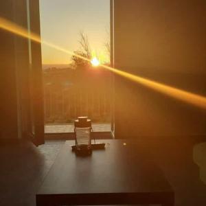 Cette chambre dispose d'une chaise et d'une fenêtre offrant une vue sur le coucher du soleil. dans l'établissement Lo scorcio della Neapolis Accogliente appartamento pressi parco Neapolis, à Syracuse