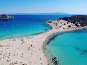 an aerial view of a beach with blue water at nafsikacottagehouse in Kissamos