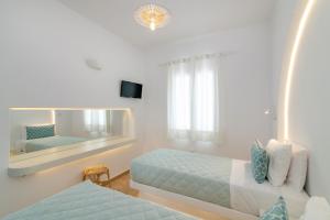 a bedroom with two beds and a large mirror at Argiro in Tinos Town