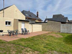 un patio con sillas y una mesa frente a una casa en Le Cosy, en Bourseville