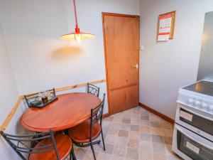 a kitchen with a table and chairs and a stove at Old Cottage in Nateby