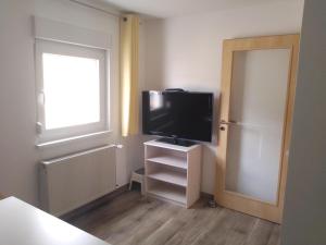 Cette petite chambre dispose d'une télévision et d'une fenêtre. dans l'établissement Ferienwohnung am Altmühlsee, à Gunzenhausen