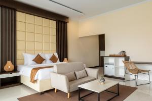 Semabu Hills Hotel Nusa Penida في نوسا بينيدا: غرفة نوم بسرير واريكة وطاولة
