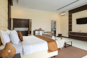 a hotel room with a bed and a television at Semabu Hills Hotel Nusa Penida in Nusa Penida