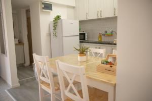 a kitchen with a wooden table and white refrigerator at רוזמרין בחרמון in Majdal Shams