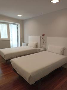 twee bedden in een kamer met bij Campanas Haus in Santiago de Compostela