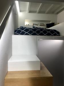 ein Schlafzimmer mit einem weißen Bett und einem weißen Regal in der Unterkunft Lola Loft in Florenz