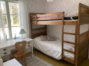 a bedroom with two bunk beds and a desk at Linsell nyrenoverad lägenhet in Linsell