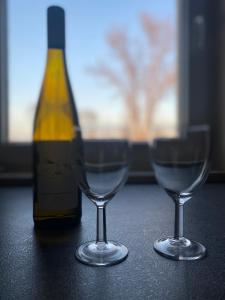 a bottle of wine and two wine glasses on a table at NM Residence in Shkorpilovtsi