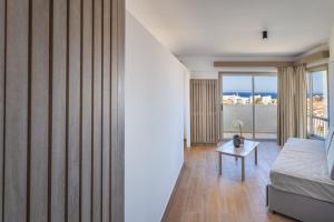 a room with a bed and a table with a window at Toxotis Hotel in Protaras
