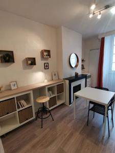 - un salon avec une table, une table et des chaises dans l'établissement Anémone - studio tout confort en centre ville, à Millau