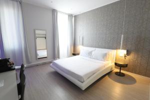 a bedroom with a white bed and a window at Cadorna Luxury Hotel in Milan