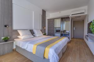 a bedroom with a large bed and a kitchen at Toxotis Hotel in Protaras
