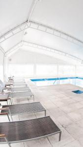 an empty swimming pool with chairs in a building at Green Sea Apart Hotel in Pinamar