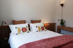 a bedroom with a bed with white sheets and pillows at Picobello Lago in Mandello del Lario