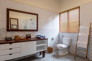 a bathroom with a toilet and a mirror at Semabu Hills Hotel Nusa Penida in Nusa Penida