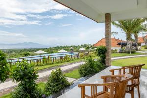 a view from the balcony of a resort with two wooden chairs at Semabu Hills Hotel Nusa Penida in Nusa Penida