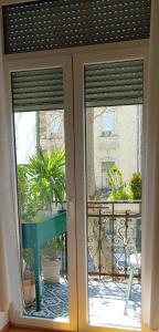 eine Glasschiebetür mit Blick auf einen Balkon in der Unterkunft Cricket Park Hostel in Belgrad
