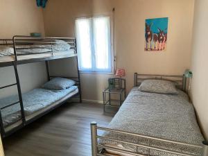 a bedroom with two bunk beds and a window at Beach house Atlantique 400m de la plage in Le Bois-Plage-en-Ré