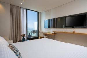 a hotel room with two beds and a television at Vert Lagoon Netanya in Netanya