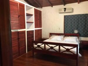 ein Schlafzimmer mit einem Bett und einigen Fensterläden aus Holz in der Unterkunft Villas la Foresta in Manuel Antonio