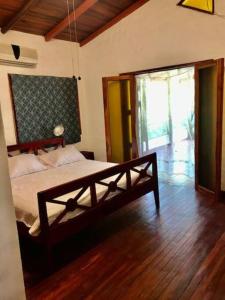 um quarto com uma cama e piso em madeira em Villas la Foresta em Manuel Antonio