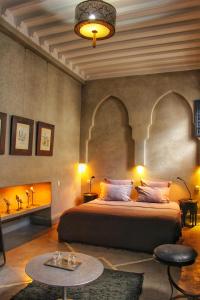 um quarto com uma cama grande e uma mesa em Riad Heva em Marrakech