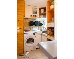 uma cozinha com uma máquina de lavar roupa e um micro-ondas em Léchappé belle em Leucate