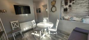 a dining room with a white table and chairs at Apartamenty Aquarius - Formoza in Gdynia