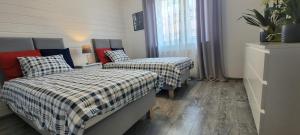 a bedroom with two beds and a window at Apartamenty Aquarius - Formoza in Gdynia