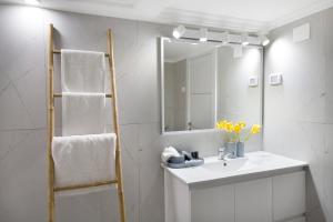 ein Bad mit einem Waschbecken und einem Spiegel in der Unterkunft Apartment with jacuzzi & pool table, Haifa center close to Bahai Garden in Haifa