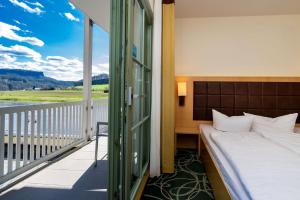 クアオルト・ラーテンにあるSTEIGER Hotel Elbschlösschen Rathenのベッドルーム1室(ベッド1台付)、景色を望むバルコニーが備わります。