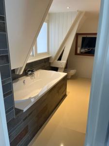 a bathroom with a bath tub and a sink at B&B Bommelsteijn in Dordrecht