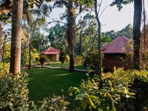 a garden with trees and a house in the background at Sanna Eco Lodge in Arusha +13 photos