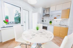 eine weiße Küche mit einem weißen Tisch und weißen Stühlen in der Unterkunft DREAM BLED Balcony Apartment in Bled + 21 Fotos