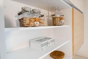 ein Regal mit Glasgefäßen und Körben darauf in der Unterkunft DREAM BLED Balcony Apartment in Bled