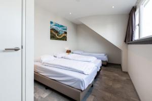 2 Betten in einem Zimmer mit weißen Wänden in der Unterkunft Group accommodation in Valkenburg