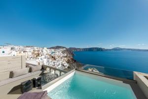 einen Pool mit Blick auf das Wasser in der Unterkunft Caldera Houses Oia in Oia