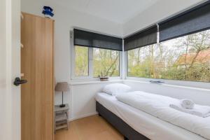 een slaapkamer met een bed en een raam bij Vebenabos 36 in Koudekerke