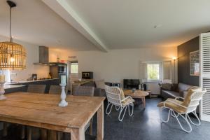 cocina y sala de estar con mesa de madera y sillas en Vebenabos 36, en Koudekerke