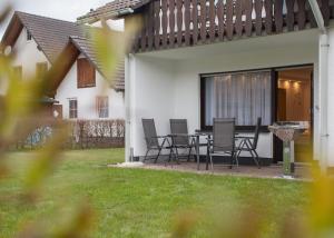 d'une terrasse avec des chaises et une table dans la cour. dans l'établissement Appartement - Zum Hohlen Rain 11 Züschen, à Winterberg