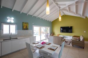 cocina y comedor con mesa y sillas en Reflection Y 5 Star Villa, en Maho Reef